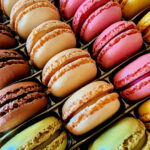 Assortment of colorful French macarons arranged in rows.