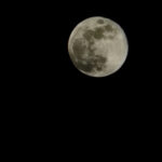 Detailed full moon against a deep black night sky.