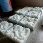 Handmade soap bars with decorative swirls arranged on a countertop.