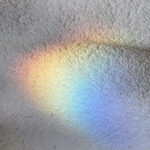 Soft rainbow light reflected on a textured surface.