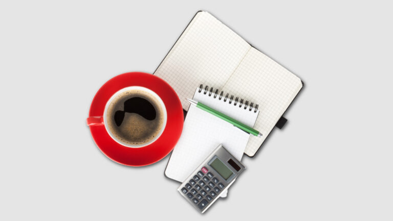 Top view of a notebook, calculator, and coffee on a desk showing a simple decision-making setup