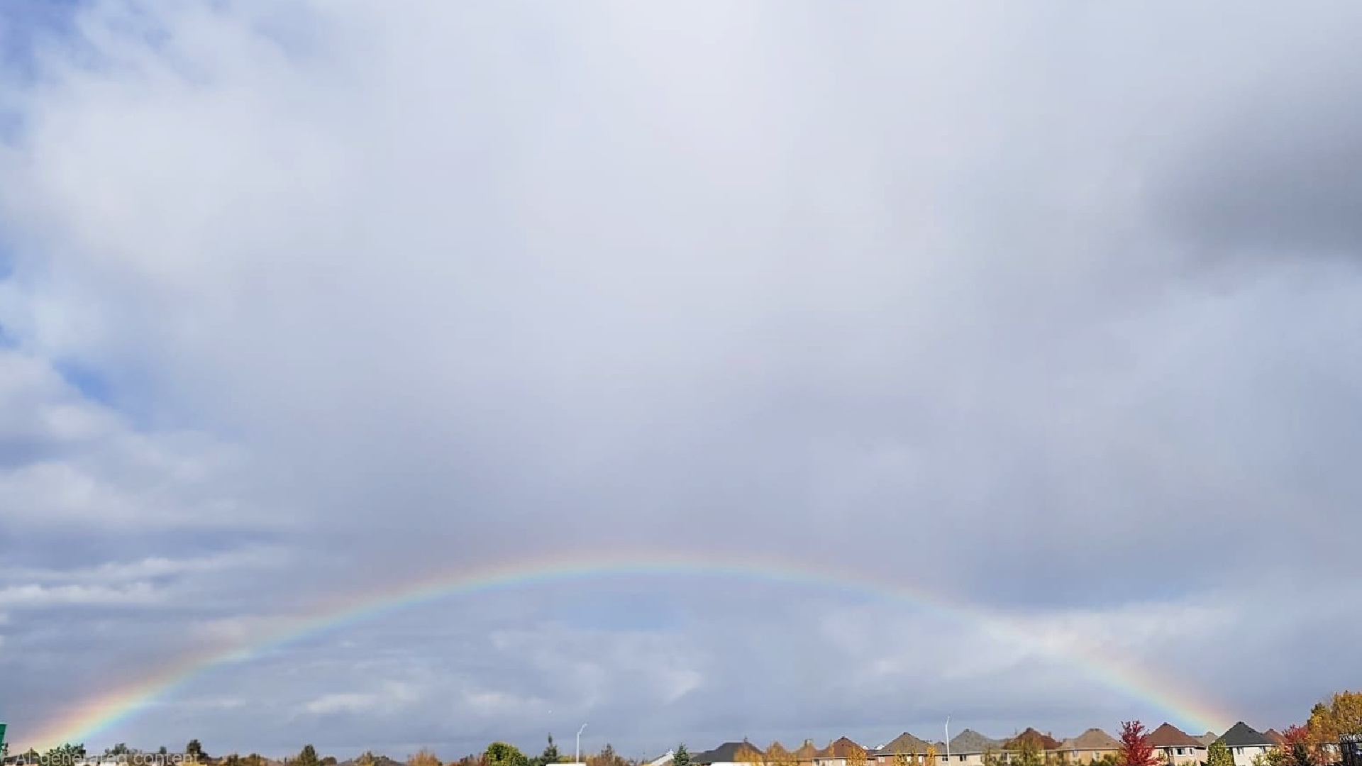 Rainbow across a cloudy sky after rain with soft natural light and subtle colors