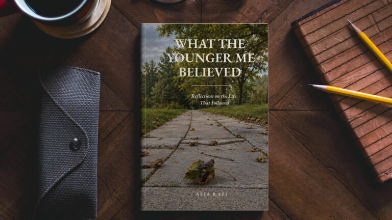 Mockup of Afia Razi’s book What the Younger Me Believed on a wooden desk beside a notebook, pencils and a cup.